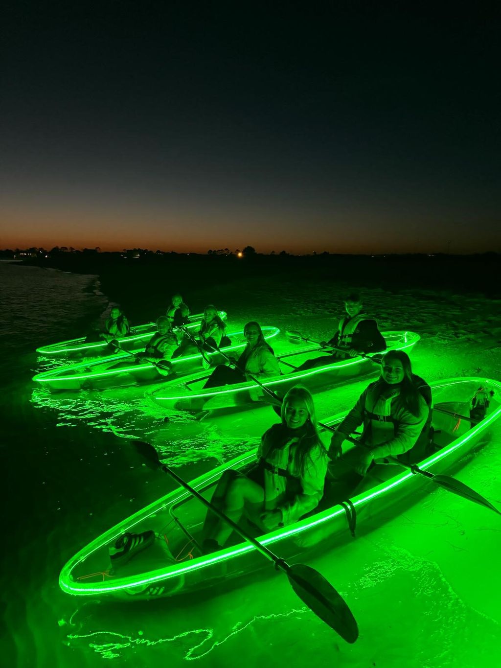 Clear kayak glowing on the water at night